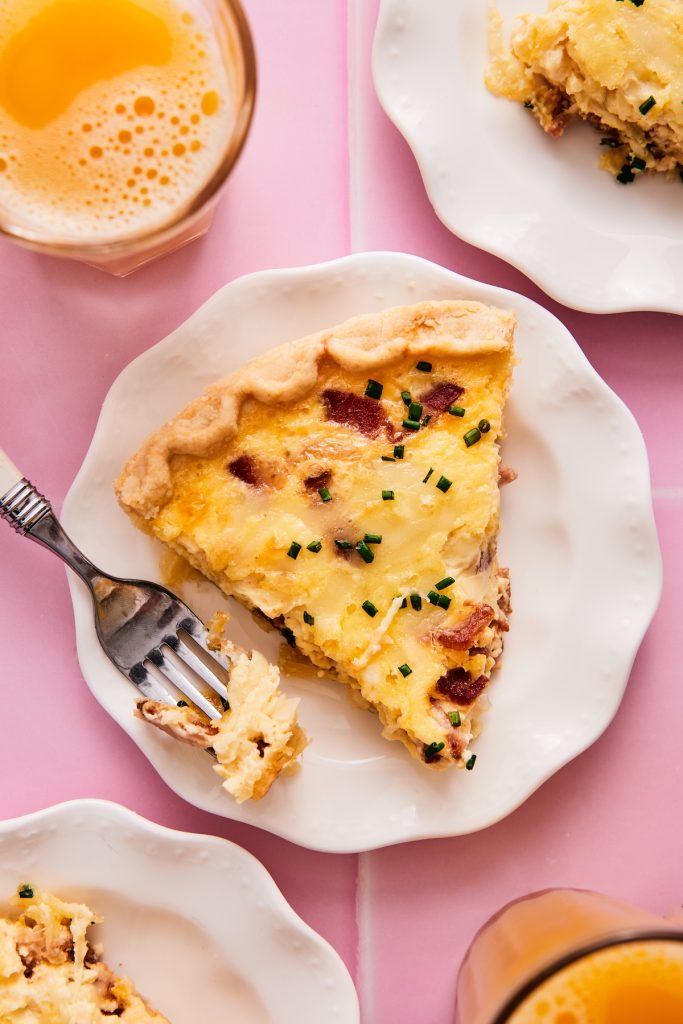Slice of quiche lorraine on a plate with a fork