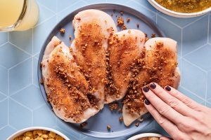 Patting spices into chicken breast