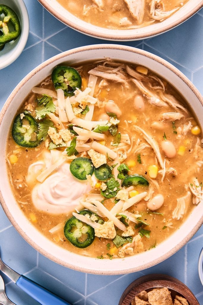Bowl of white chicken chili with fresh garnishes