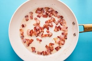 Diced bacon in a fying pan cooking