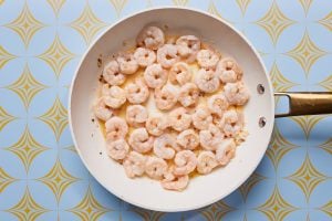 Skillet with cooked shrimp and garlic butter