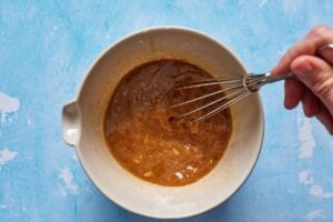stir fry sauce in a bowl with a whisk