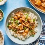 bowl of almond chicken stir fry over rice on a blue background