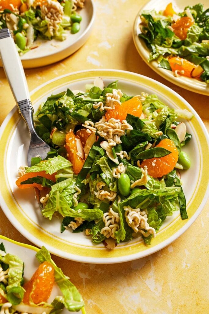 mandarin orange salad with ramen on a yellow plate and yellow background