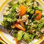 plate with mandarin orange salad with a fork on a yellow background