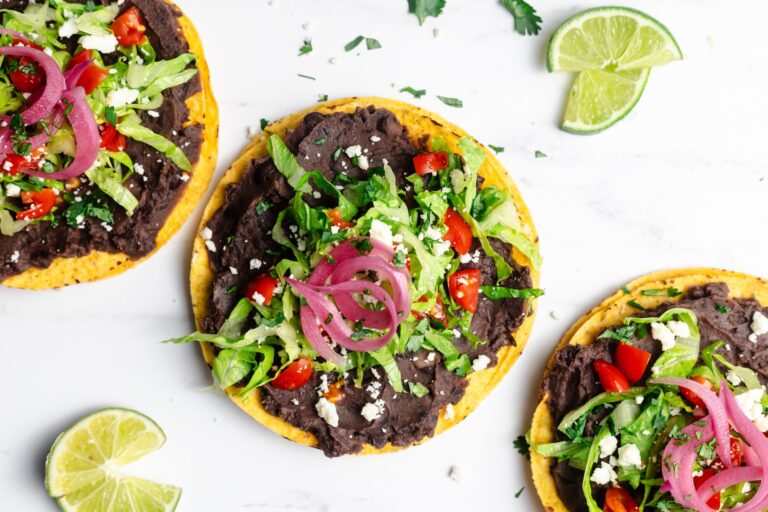 Three black bean tostadas with fresh toppings